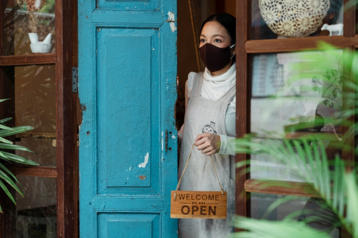 Serious ethnic woman at rural shop doorway