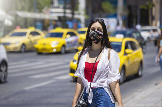 A Tourist Woman Wearing A Cloth Face Mask Walks On The Busy Streets Of Athens